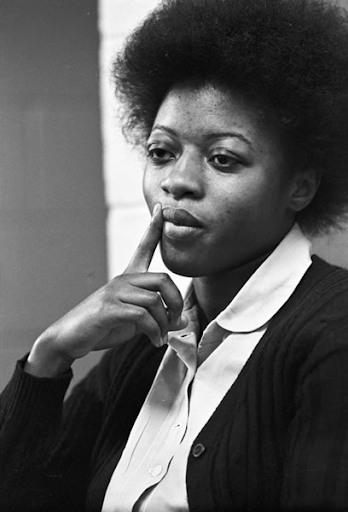photo of joan little with holding a finger to her lips 