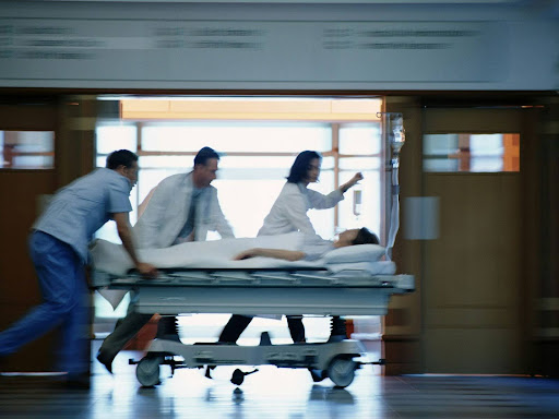 medical professionals running with a patient on a gurney