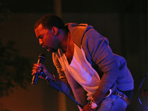 kanye west singing into microphone