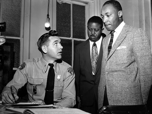 martin luther king standing up with others in a room