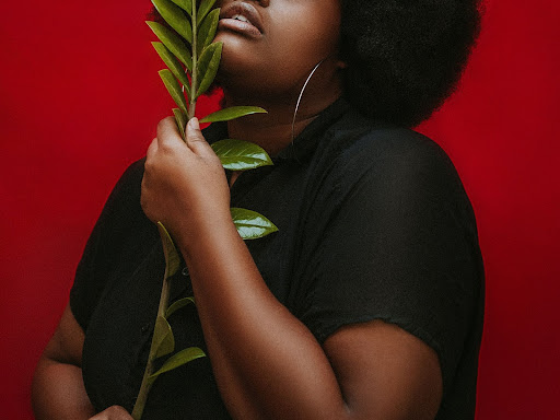 black woman holding a plant 