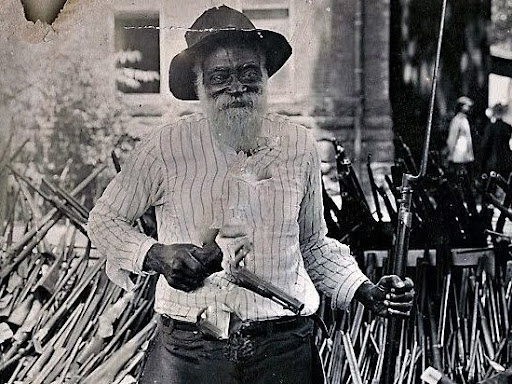 black man holding a gun and bayonet 