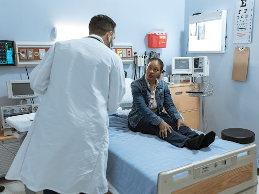 doctor talking to a patient sitting on a bed