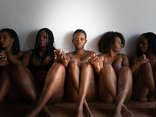 black women sitting down with legs and arms crossed