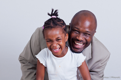 black father embracing his young black daughter