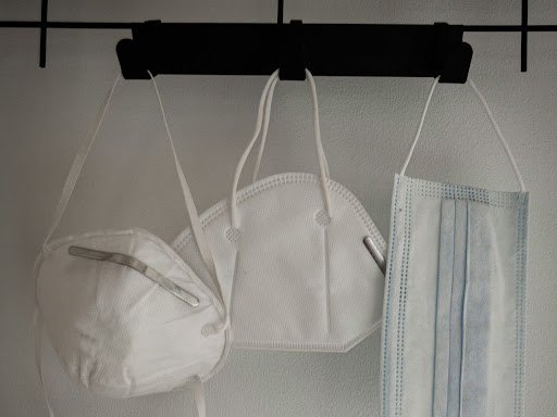 masks and white and blue towel hanging on white wall