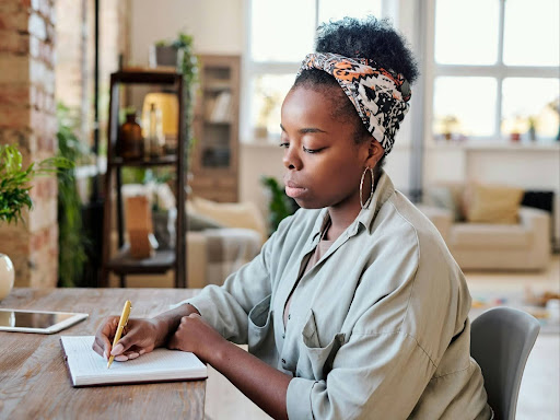 young black woman in earrings sitting at a table