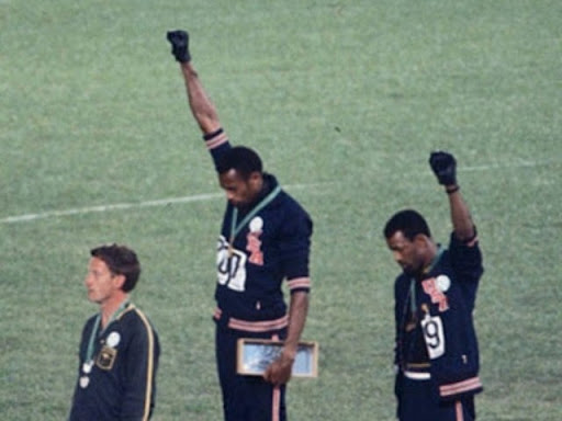 two black olympians raising their fists in solidarity on the podium 
