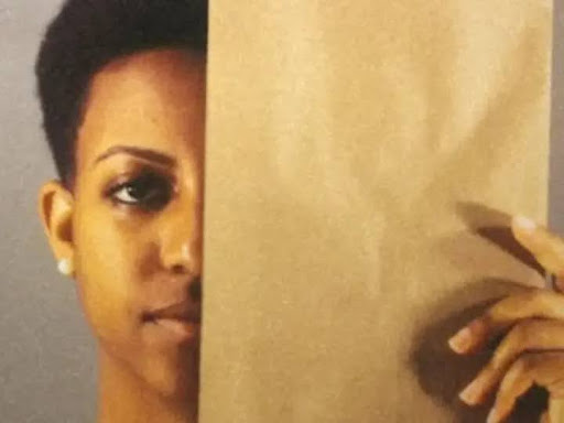 black person holding face up to brown paper bag