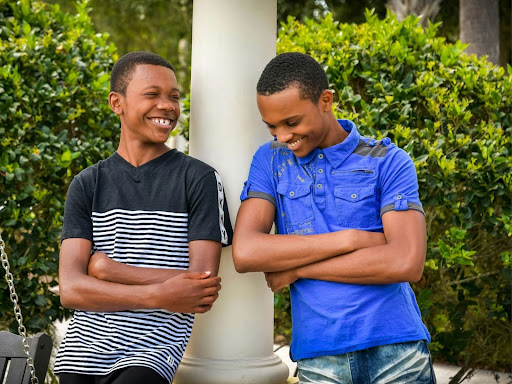 two people standing next to each other with arms crossed