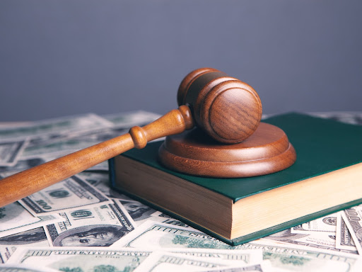 gavel sitting on top of a book on top of a pile of money