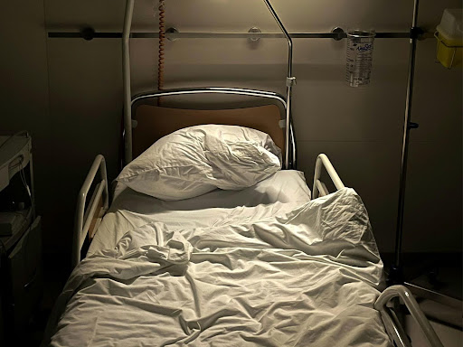 unkempt hospital bed with a monitor