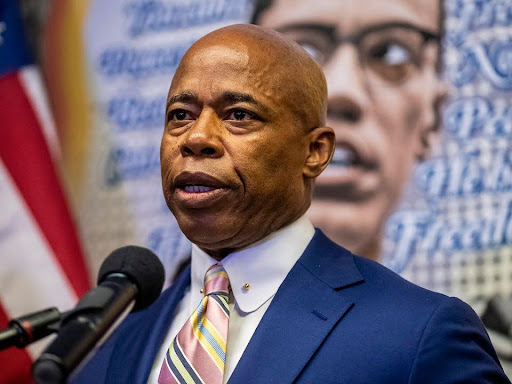 mayor eric adams speaking at a microphone