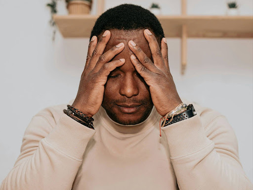 black man covering his eyes with his hands