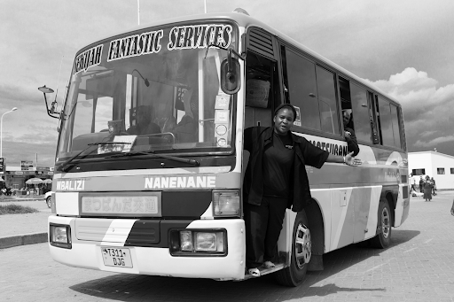 a woman at work as a mini bus conductor