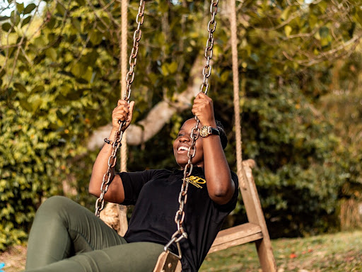 black on a swing outside smiling