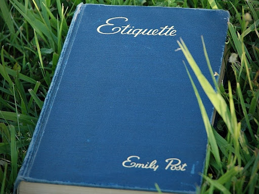 etiquette book laying in green grass