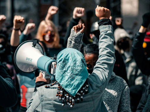 people raising their fists together at a protest 