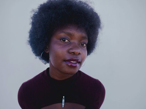 black woman with an afro posing for a picture