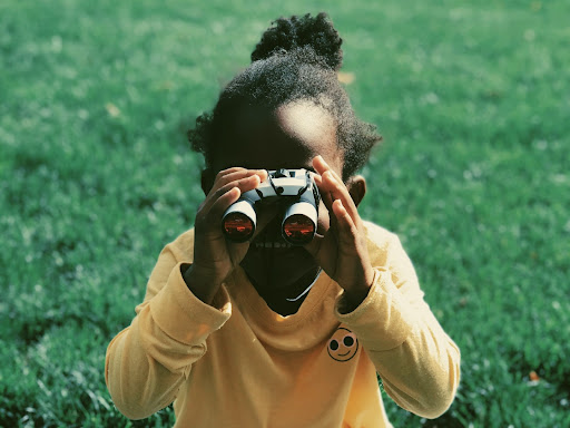 little girl looking through binoculars