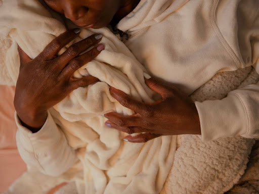 a woman holding a baby wrapped in a blanket