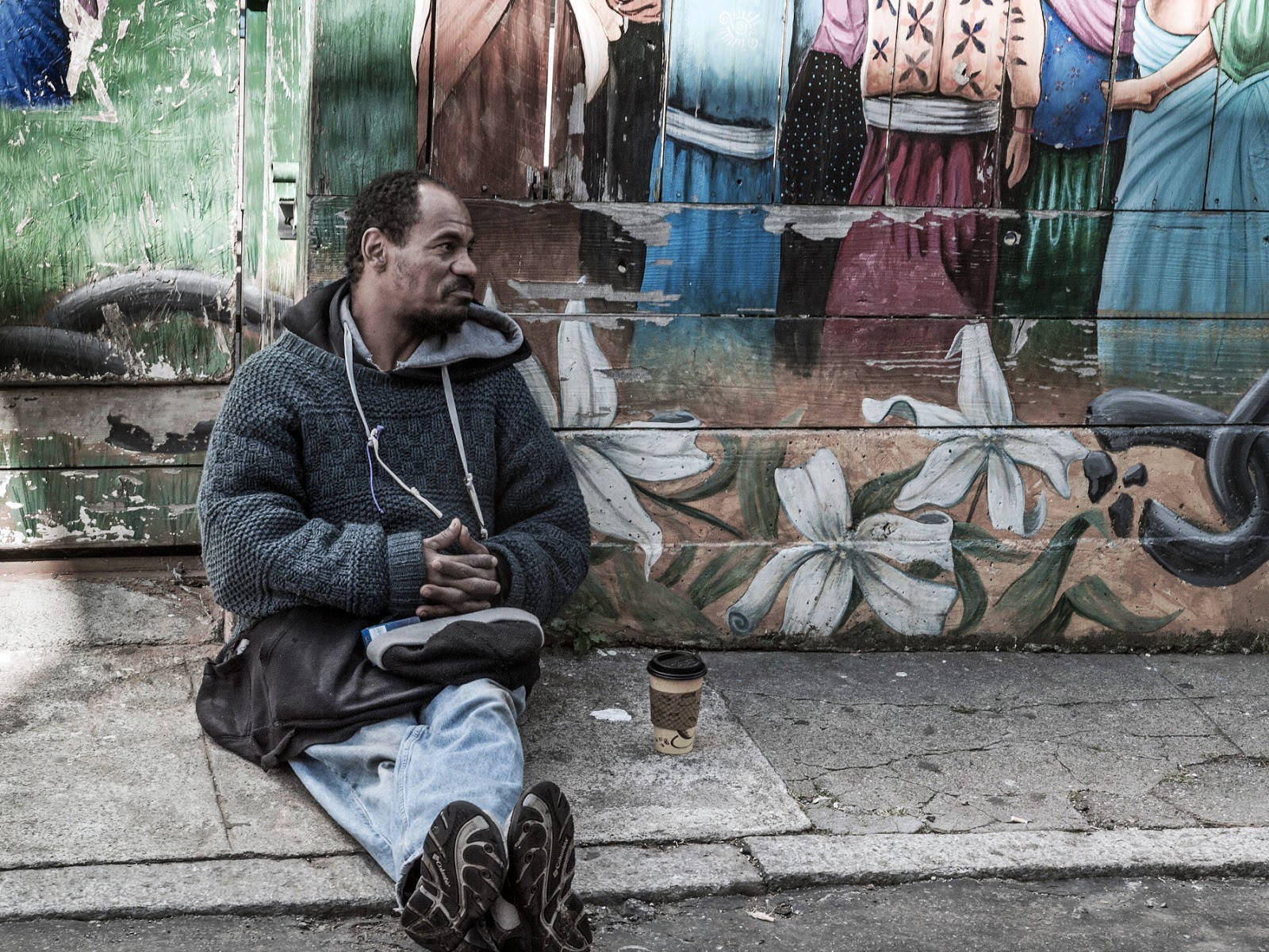 Homeless man sitting on sidewalk
