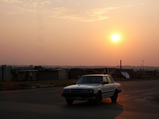 car driving on the road with the sun setting