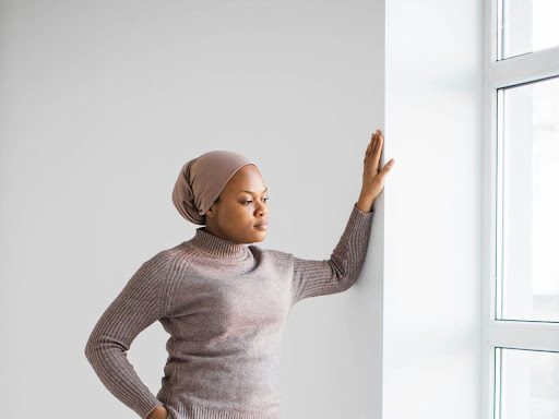 black muslim woman in a headscarf by a window