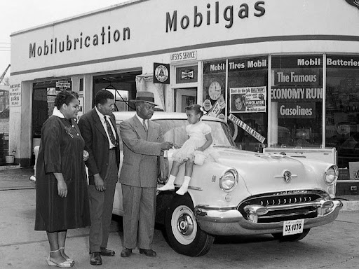 a black family in front of a gas station
