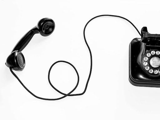 black rotary phone against white background