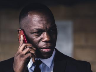 black man holding up a cellphone to his ear