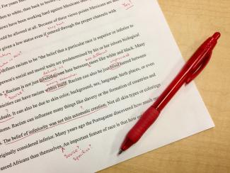 A report marked up in red pen