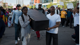 Young men holding coffin