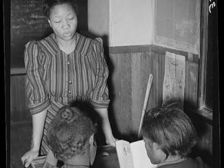 school children reading with black teacher