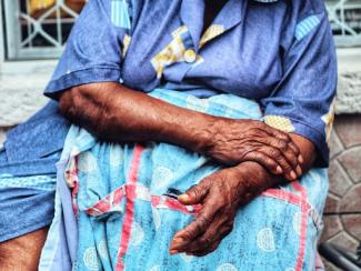 Older Black Woman holding her arm