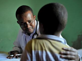 black doctor examining a small black child
