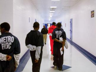 Young inmates walking in hallway