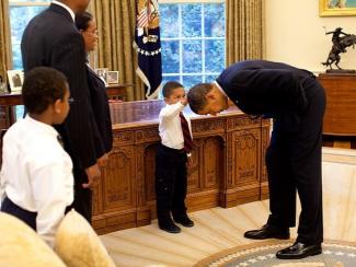 Via <a href=https://commons.wikimedia.org/wiki/File:United_States_President_Barack_Obama_bends_down_to_allow_the_son_of_a_White_House_staff_member_to_touch_his_head.jpg>Wikimedia Commons</a> 