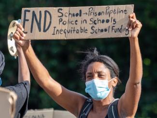 protestor holding a sign at a protest for george floyd