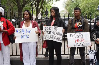 Demonstrators holding "Say Her Name" signs