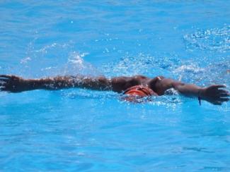 black man doing the breast stroke in a pool