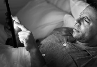 Man on tablet in bed