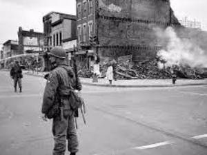 building on fire with a soldier nearby