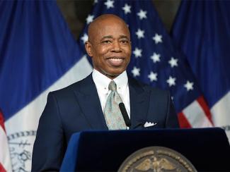 mayor eric adams in front of a podium 