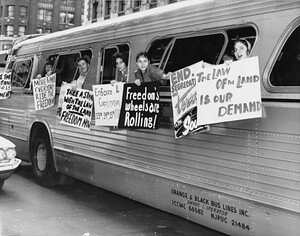 “Freedom Riders” hang anti-segregation signs from bus windows