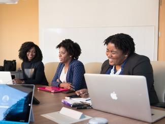Women of color at conference room table