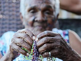 Elderly woman holding beads