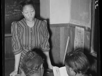 black female teacher instructing students