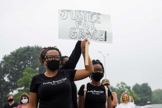 Woman holding "Justice For Grace" sign