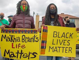 Mourners holding signs that read Ma'Khaia Bryant's Life Matters
